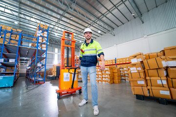 Naklejka premium Caucasian warehouse worker man action of pull cargo small truck that carry product boxes in area of workplace.
