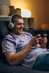 Adult Caucasian man is playing video games on his mobile phone