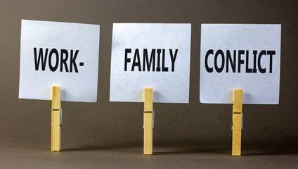 Work-family conflict symbol. Concept words Work-family conflict on white paper on wooden clothespin on a beautiful grey table grey background. Business work-family conflict concept. Copy space.