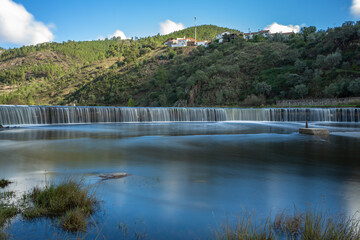 Long exposure of the waterfall in Ocreza beach on a beautiful sunny day, located in the village of Foz do Cobrao and Portas de Amourao, Proenca-a-Nova, Portugal