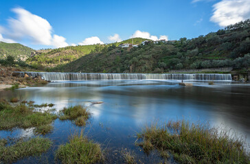 Long exposure of the waterfall in Ocreza beach on a beautiful sunny day, located in the village of Foz do Cobrao and Portas de Amourao, Proenca-a-Nova, Portugal