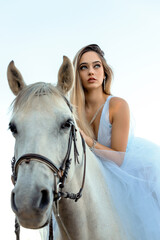 blonde girl riding a white horse