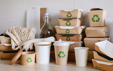 Recycling concept. Disposable tableware and packaging made from biodegradable materials with a green recycling symbol