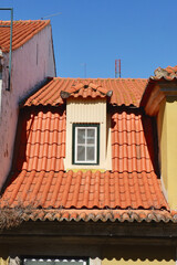 Vintage tiled roof with tiny window of authentic Portuguese building downtown Lisbon, Portugal
