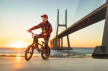 BMX Tricks For Beginners. A teenager bike racing rider in a skate park on a pump track.