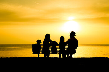 Fototapeta na wymiar A happy family in nature by the sea on a trip silhouette