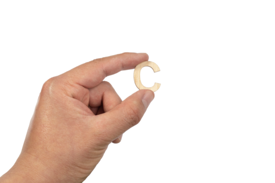 Close up of a person's hand holding a small wooden letter C isolated on a white background
