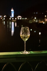 Tasting of french sparkling white wine with bubbles champagne outdoor at night with view on Marne river and lights of Epernay city in winter