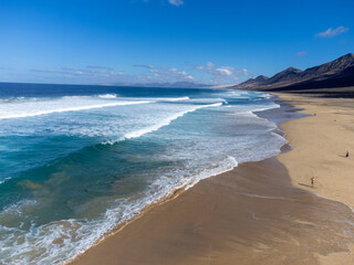 Aerial view on difficult to access golden sandy Cofete beach hidden behind mountain range on Fuerteventura, Canary islands, Spain