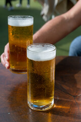 Fresh draught lager or IPA beer is glass served in outdoor cafe close up, pint of beer close up