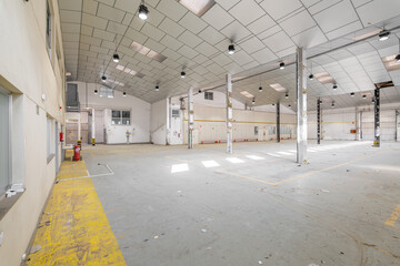 Parking garage with lights, light-colored walls, metal beams and ceiling prepared for renovation...