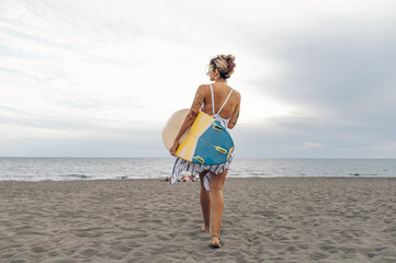 Portrait of a surfer woman posing with surfboard on a beach