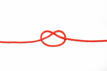 Red rope with a knot not completely tied on a white isolated background. Red nylon rope with an...