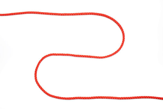 Red rope twisted in the form of a zigzag on a white isolated background. Red nylon rope lies on a white background, top view. Free space for text