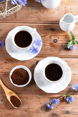 Chicory beverage, chicory powder and blue flowers on a table. Useful herbal drink without caffeine. View from above.