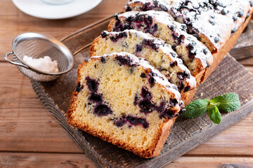 Summer loaf of fresh blueberry muffin bread cake decorated with mint closeup on a table