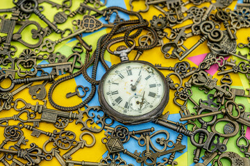 The concept of symbolism. Antique rotten pocket watch with Bronze ornamental keys on a background...