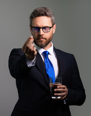 Head pain medicines pills concept. Cephalalgia and migraine. Man with sinus headache, tension or cluster headache on gray studio. Man taking a medicine pill from headache migraine.