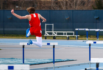 Runner jumping over a track hurdle during a race