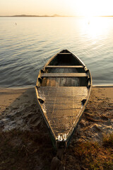 canoe anchored in the sand of a lagoon during dawn