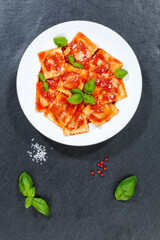 Ravioli pasta meal from Italy lunch dish with tomato sauce top view on a plate portrait format