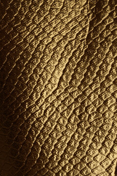 Gold and bronze litter foil paper. Abstract reptile skin imitation texture background.