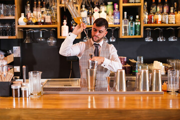 Young mixologist preparing innovative drinks to surprise his customers and improve his business. Concept: drinks, free time, drinking