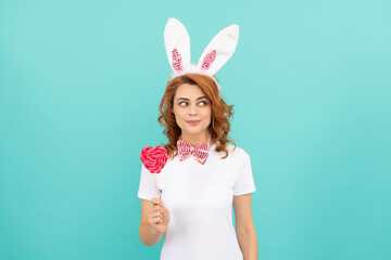 cheerful easter woman wear bunny ears hold heart lollipop