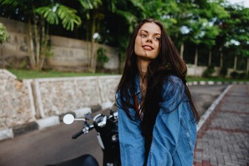 Portrait of woman brunette smile with teeth running down the street against backdrop palm trees in the tropics, summer vacations and outdoor recreation, the carefree lifestyle of a freelance student.