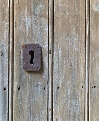 Weathered wooden door and rusty keyhole, Ragusa, Sicily