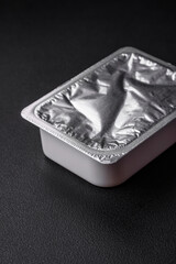 Rectangular plastic box with yogurt or cheese hermetically sealed with a foil lid