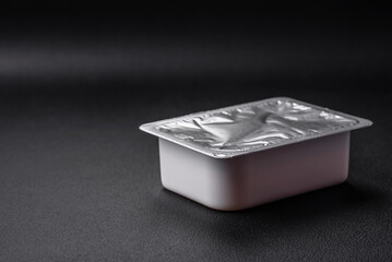 Rectangular plastic box with yogurt or cheese hermetically sealed with a foil lid