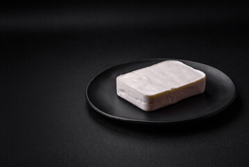 Delicious fresh rectangular shaped feta cheese with spices and vegetables