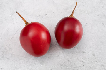 Closeup Fresh Tamarillo Fruit On Table. Egg-shaped Edible Fruit Known As Tree Tomato, Plant Family Solanaceae, Solanum Betaceum. Top View. Flat Lay. Horizontal Plane