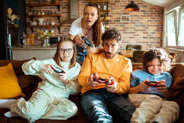 Young family playing video games together in the living room on a gaming console