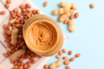 peanut butter and raw peanuts on a colored background