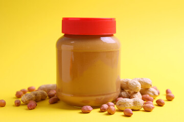 peanut butter and raw peanuts on a colored background