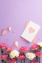Mother's Day surprises concept. Top vertical view flat lay of pretty pink paper hearts, and carnation flowers with postcard on a soft pastel violet background with space for text
