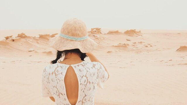 Female vlogger tourist content creator visit explore take photo of Fossil Dunes Structures in desert. Abu Dhabi, UAE. Famous travel destination and Star War movie filming location