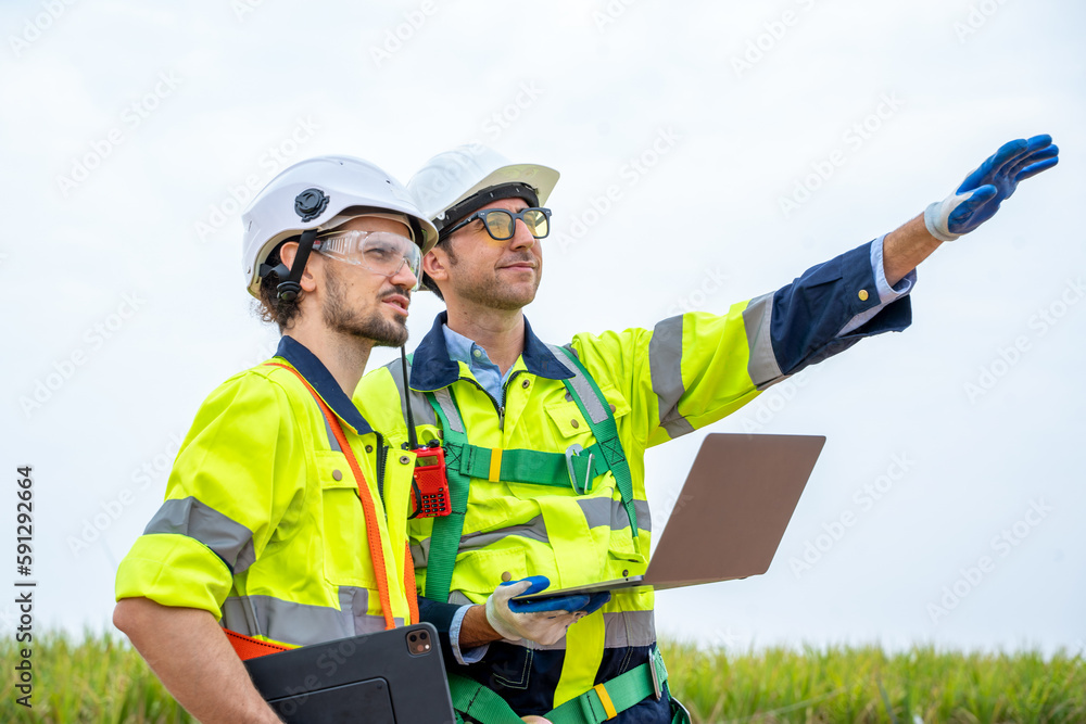 Poster engineer inspection and survey work in wind turbine farms rotation to generate electricity energy.