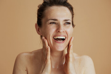 smiling young woman with wet face washing