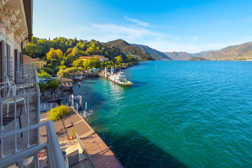 View from a balcony terrace overlooking the ferry stop and lakefront promenade at the village of Bellagio, Italy, on Lake Como in the Lombardy region.