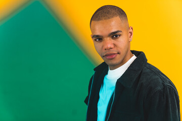 Young African American man on yellow studio background with square green light. High quality photo