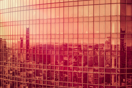 Bruxelles, reflets de la ville sur les vitres d'un gratte-ciel au coucher du soleil.