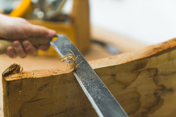 Closeup shot of traditional woodworking hand tool - drawshave - used by unrecognisable carpenter in...