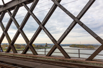 Top view onto the river Rhine through the steel girders (rhombus, cross) of a crossing railway bridge