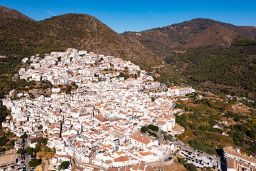 Fototapeta na wymiar Ojen, small Spanish old town village of white Andalucian houses with green nature around on a sunny day