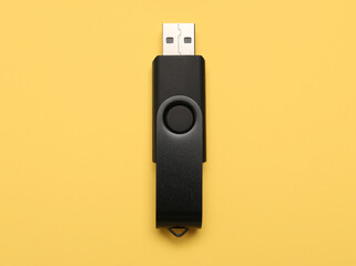 Black USB flash drive on yellow background