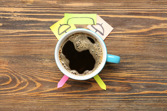 Creative composition with cup of coffee and sticky notes on wooden background