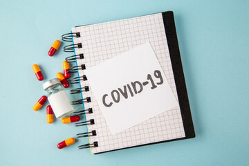 top view antivirus vaccine with pills and covid- note on blue background lab disease covid- isolation pandemic virus health color